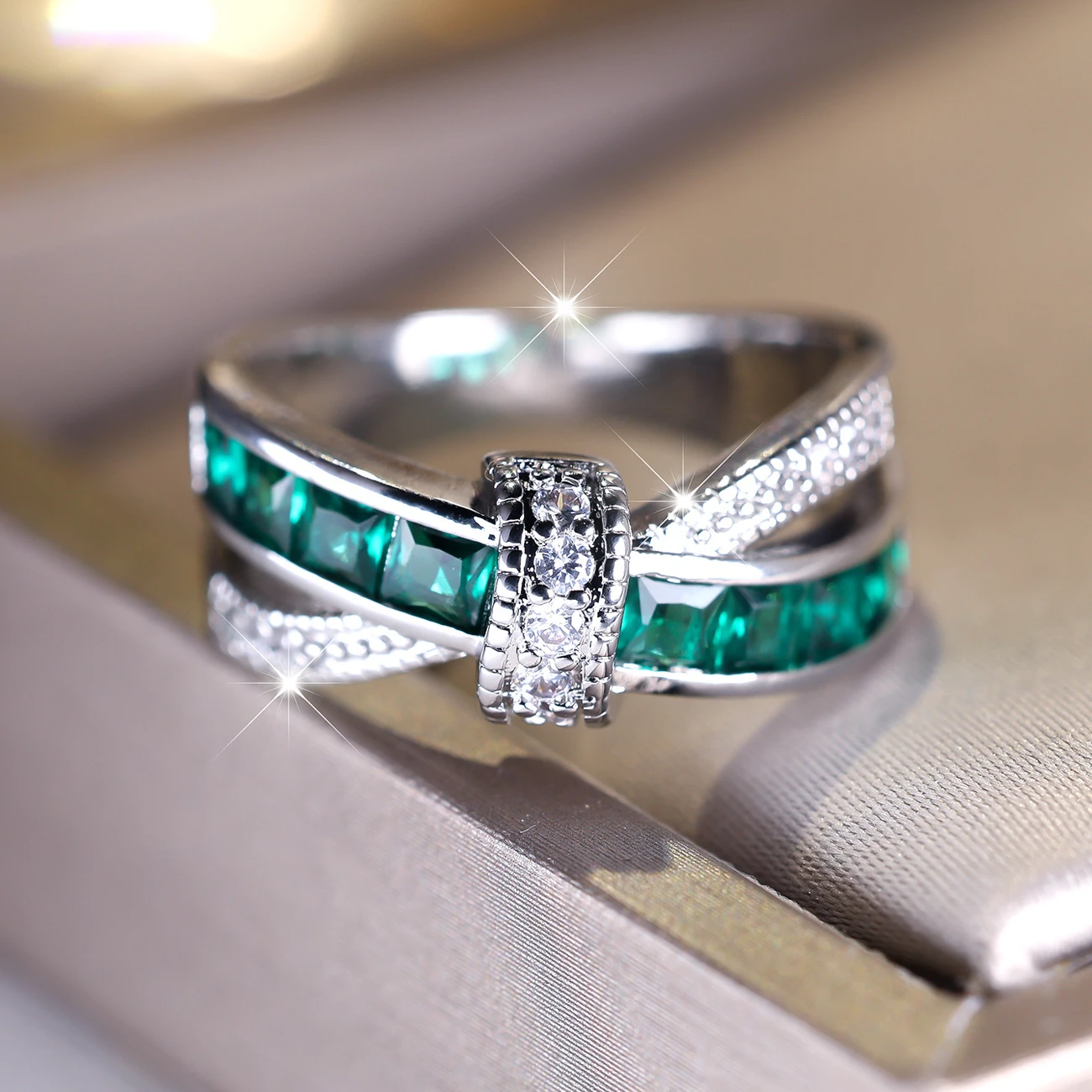 Silberring gekreuzt mit grünen Kristallen